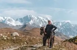 Voyage en Géorgie — Cavalier traditionnel devant les sommets enneigés du Grand Caucase en haute altitude.