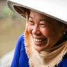 Travel in Asia - A Vietnamese woman wearing a traditional non la hat smiling broadly