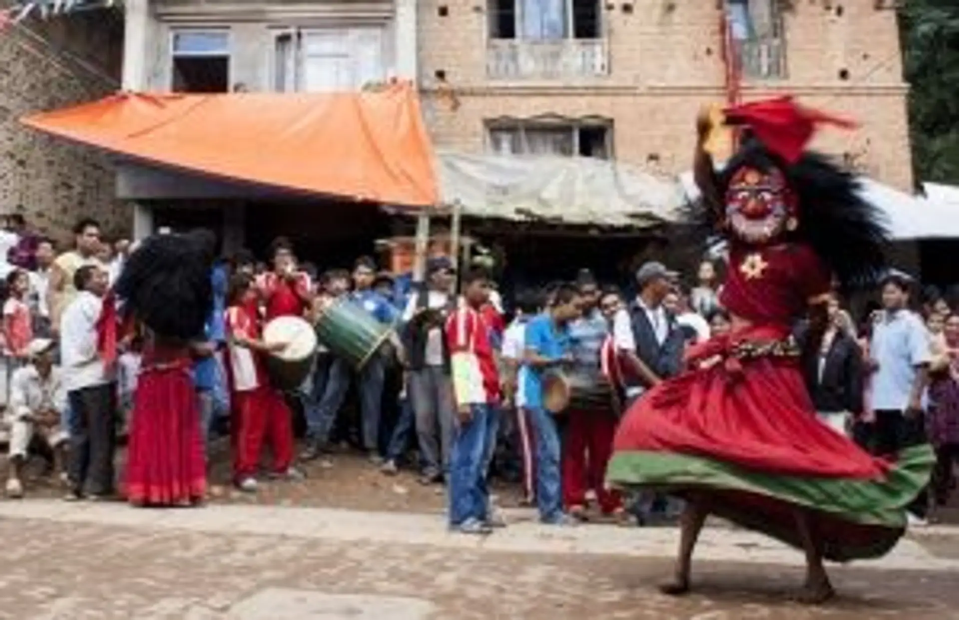 Voyage au Népal — Célébration du festival Holi avec des pigments colorés sur les visages de locaux souriants.