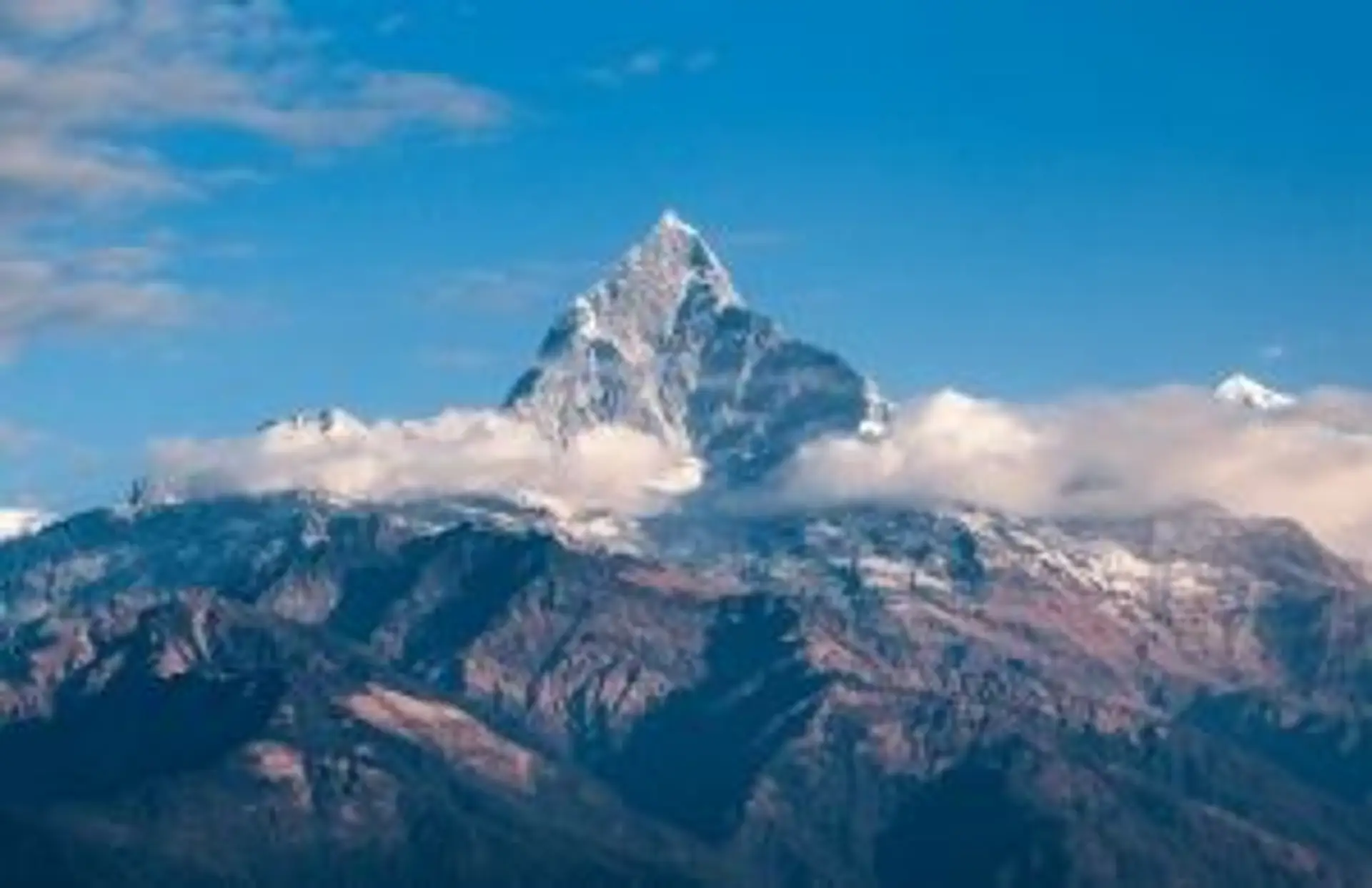Voyage au Népal — Le sommet emblématique du Machhapuchhre (Fish Tail) s'élevant au-dessus des nuages dans la chaîne de l'Himalaya.
