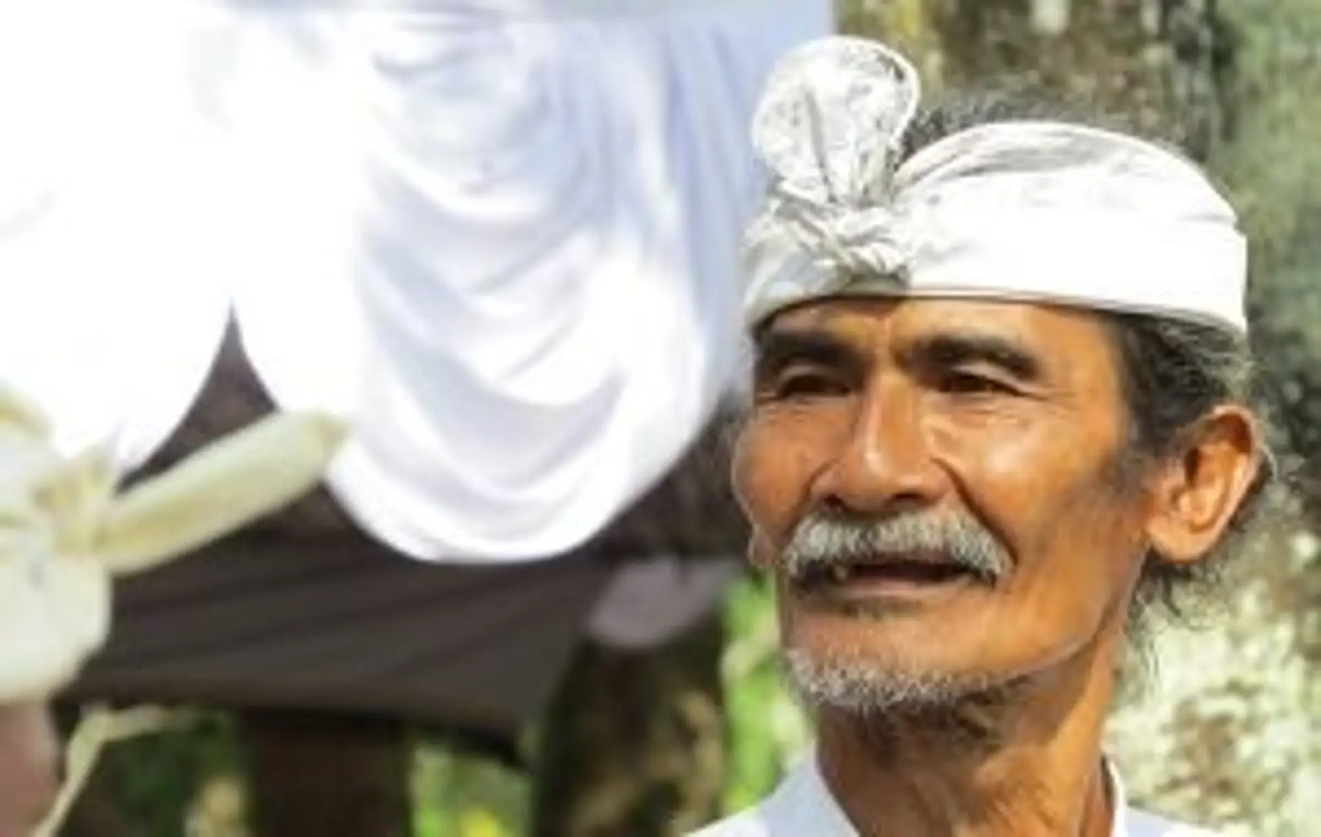 Portrait d'un homme javanais âgé portant un couvre-chef traditionnel blanc, illustrant l'identité culturelle de l'île de Java.