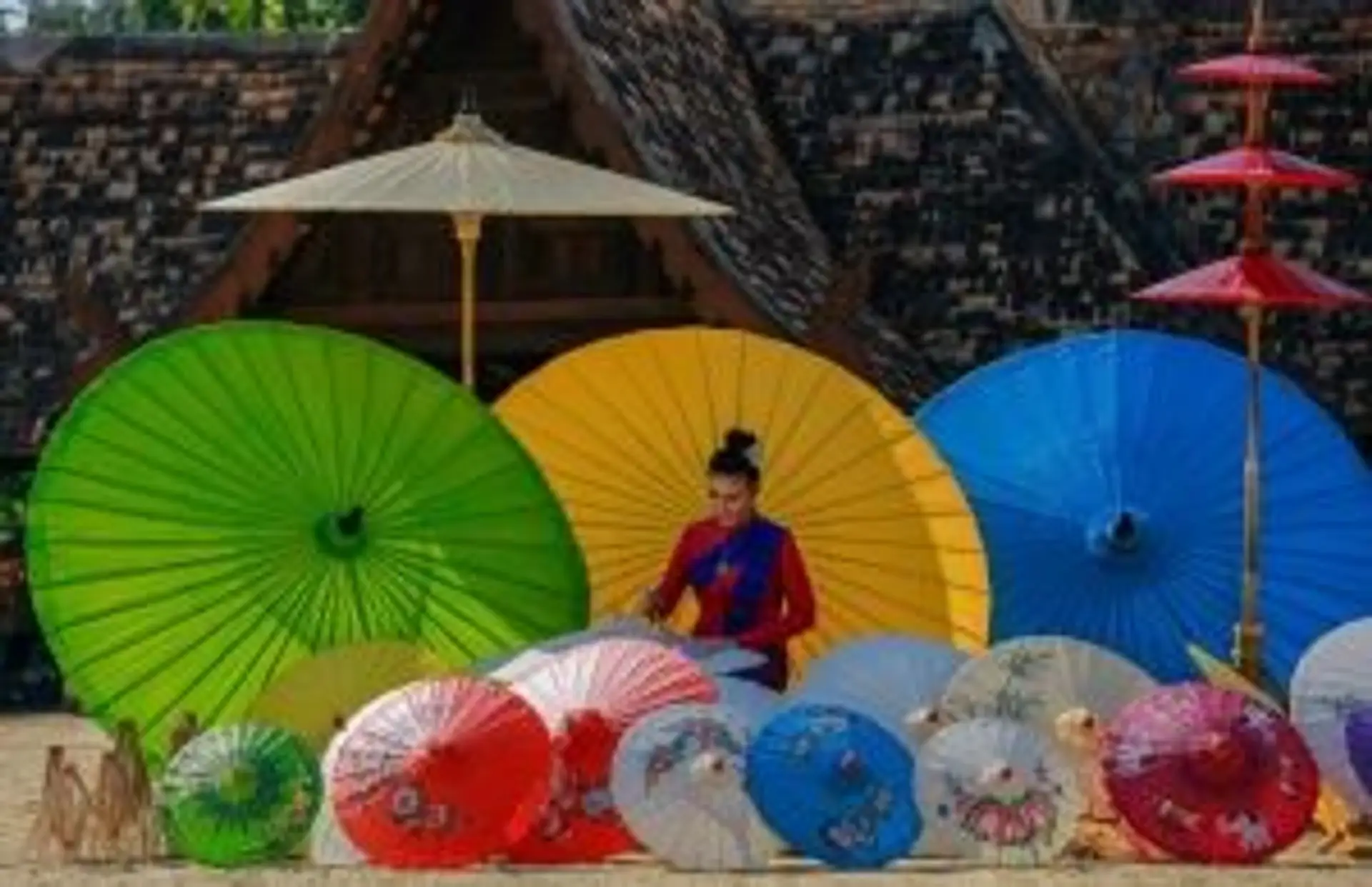 Femme confectionnant des ombrelles traditionnelles en papier coloré à Chiang Mai Thaïlande