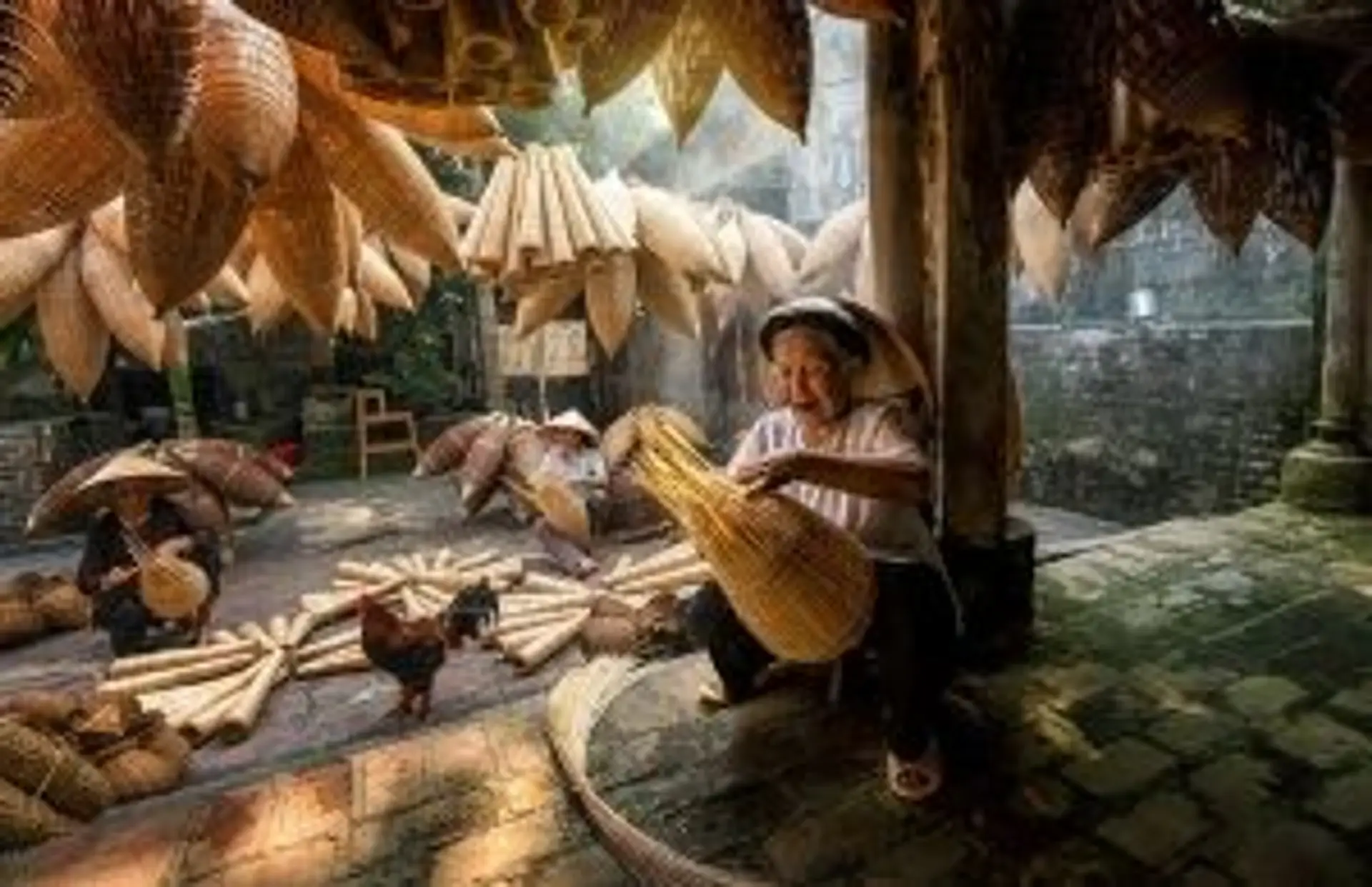 Travel Asia - A person weaving a fish trap indoors in Vietnam