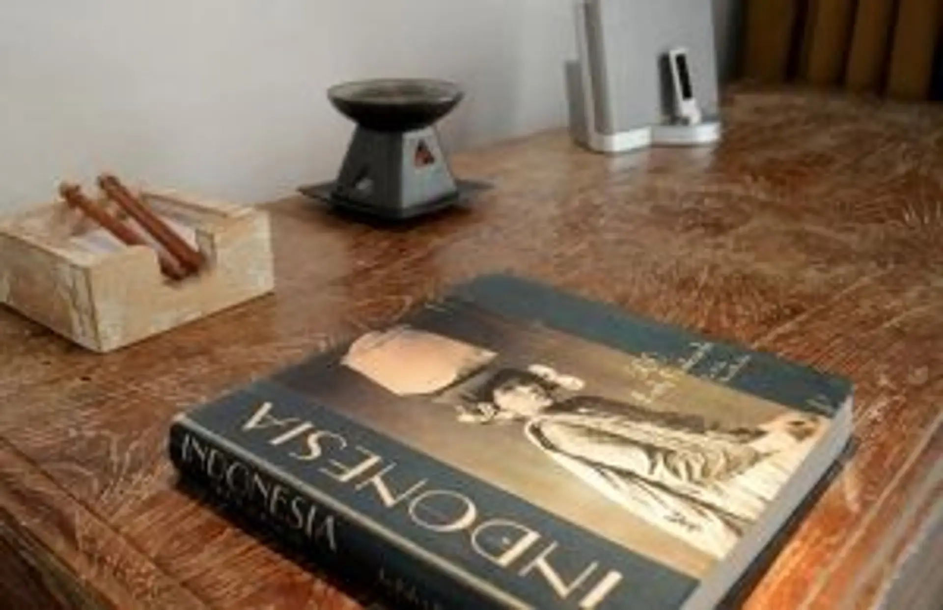 Sélection de livres et guides de voyage sur l'Indonésie posés sur une table en bois pour préparer son départ.