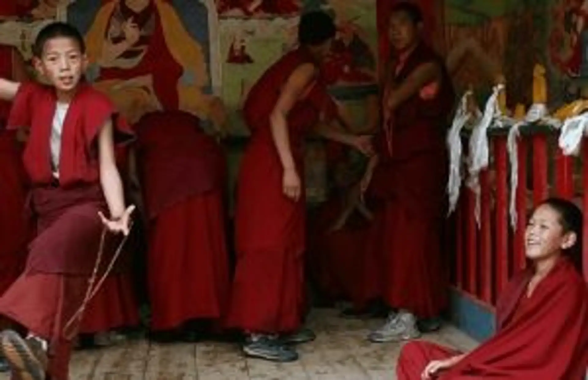 Jeunes moines bouddhistes en robes rouges traditionnelles à l'intérieur d'un temple au Vietnam