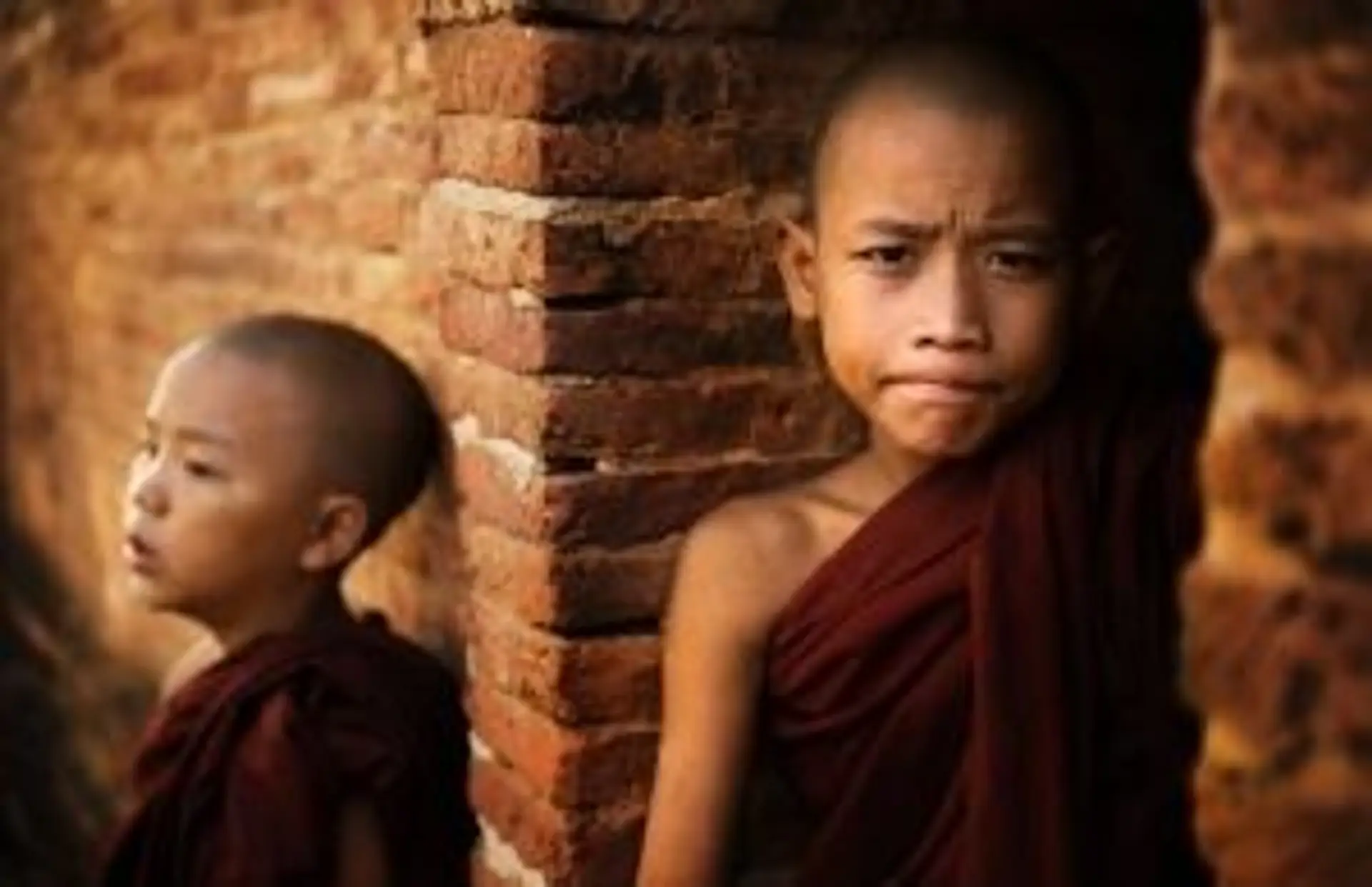 Portrait de deux jeunes moines novices bouddhistes devant un temple en Birmanie