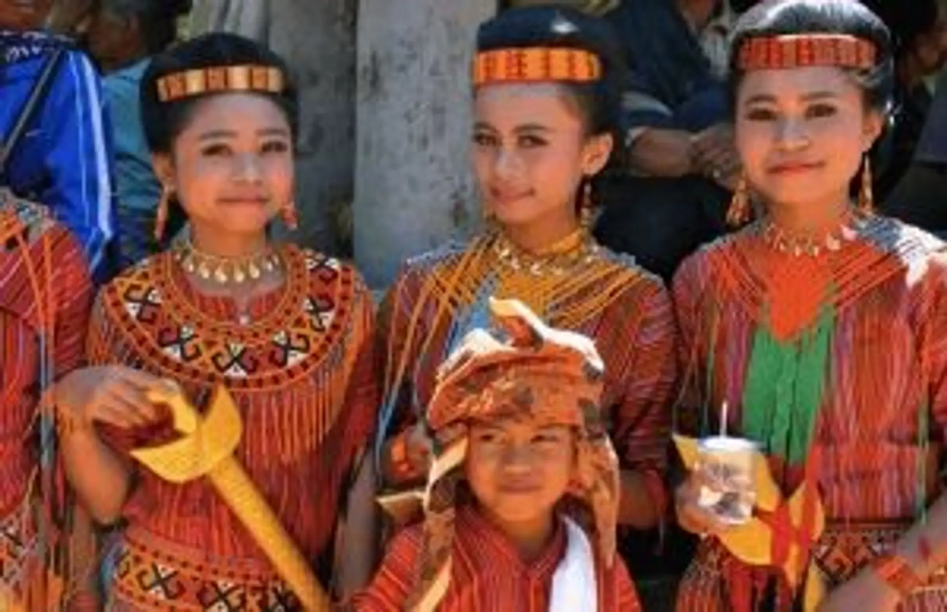 Jeunes filles indonésiennes en costumes traditionnels colorés et parures dorées lors d'une cérémonie culturelle.