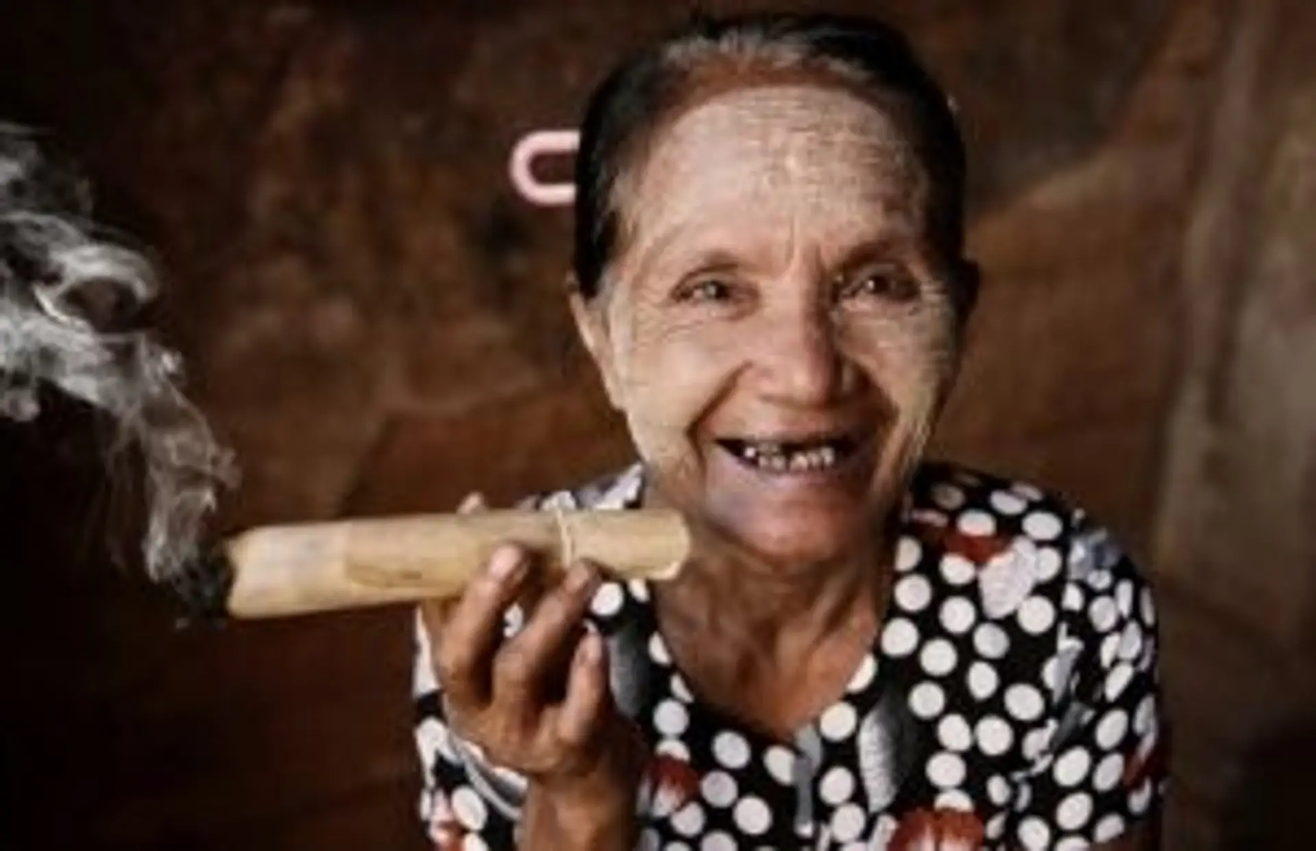 Portrait d'une femme d'une ethnie locale fumant un cigare traditionnel en Birmanie