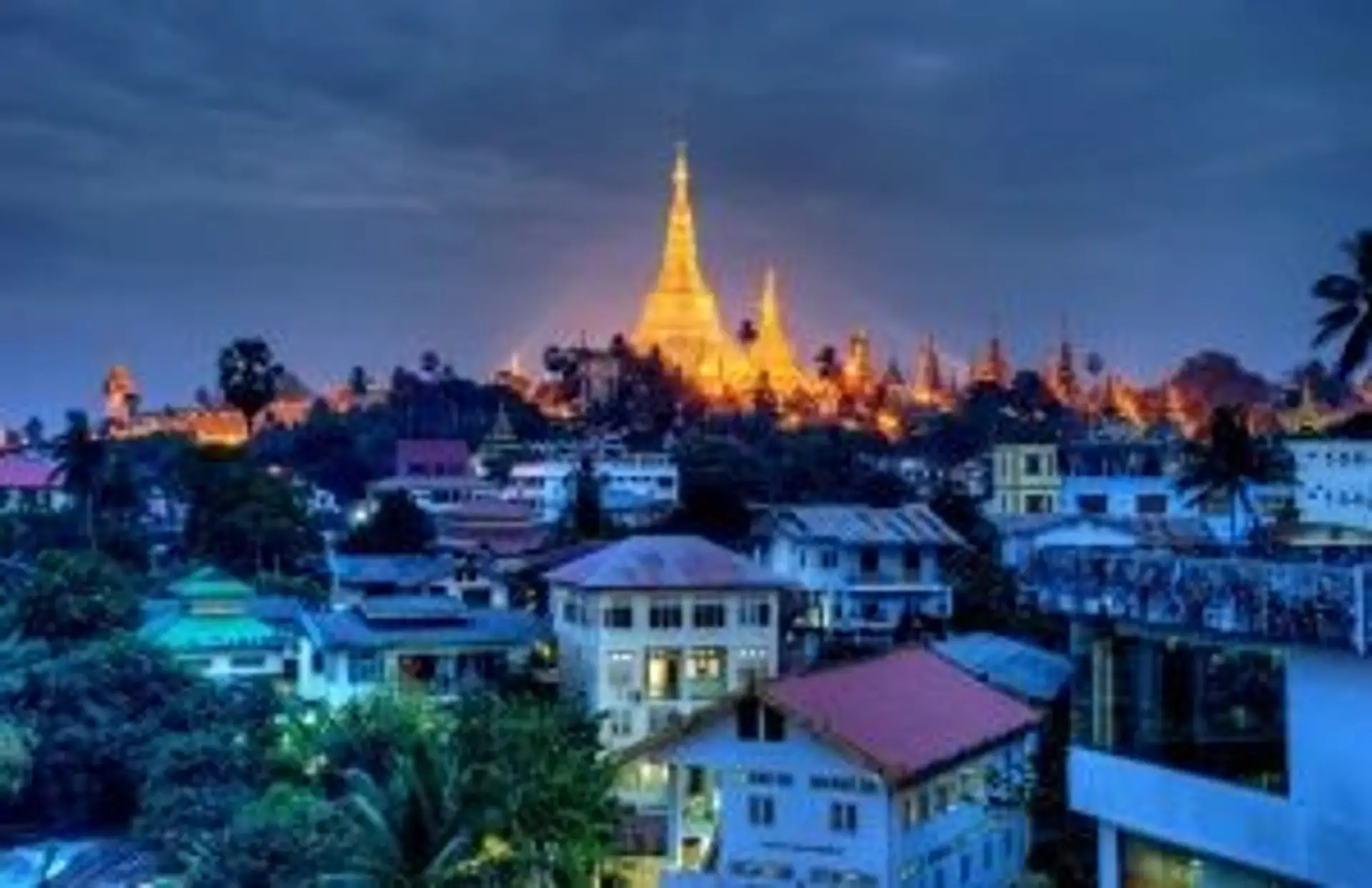 La pagode Shwedagon illuminée de nuit dominant la ville de Yangon en Birmanie