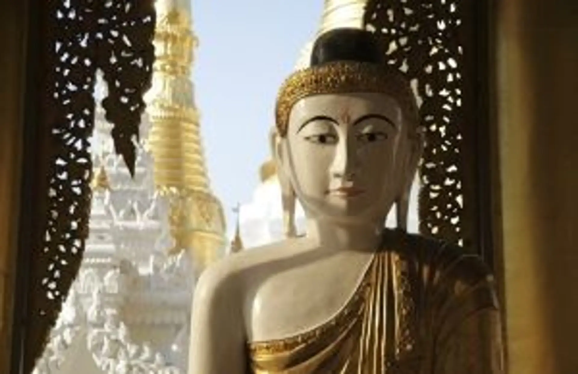 Voyage en Birmanie — Un jeune moine bouddhiste en robe traditionnelle rouge devant les temples millénaires de Bagan.