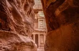 Voyage en Jordanie — Vue du Trésor (Al-Khazneh) à travers les parois étroites du Siq dans la cité antique de Pétra.
