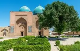 Voyage en Ouzbékistan - Vue sur les madrasas aux dômes bleus de la place du Régistan à Samarcande au coucher du soleil.