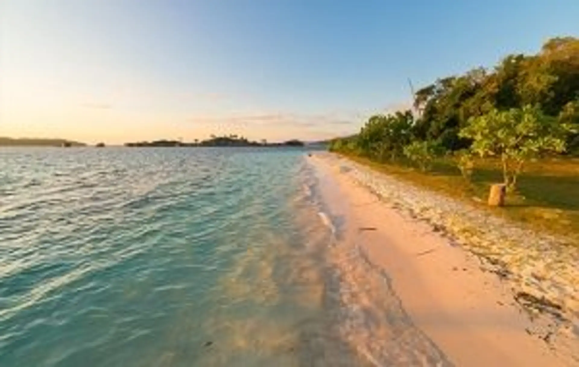 Une pirogue traditionnelle en bois sur une plage de sable blanc bordée d'eaux turquoise à Sulawesi