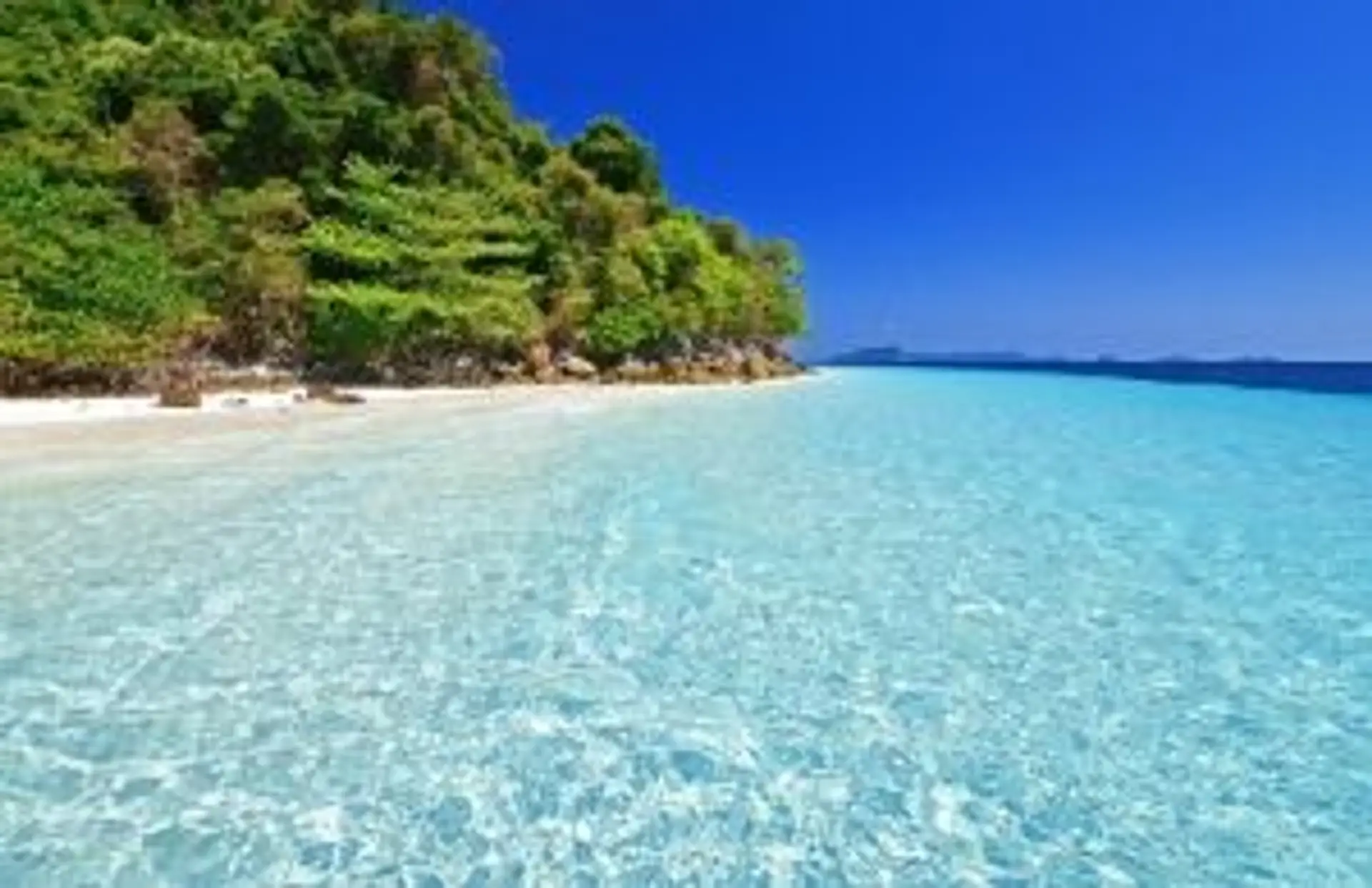 Voyage en Birmanie - Plage de sable blanc et eaux turquoise bordées de végétation tropicale à Ngapali.