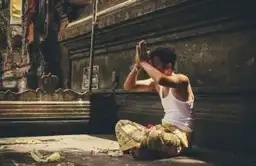 Religions en Indonésie : un fidèle en prière dans un temple balinais, symbole de la ferveur spirituelle de l'archipel.