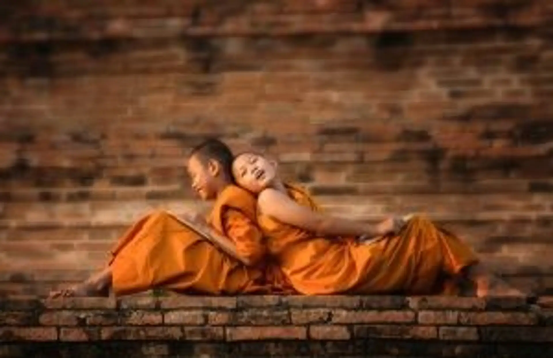 Jeunes moines novices bouddhistes en robe safran se reposant dans un temple en Thaïlande