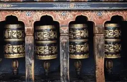 Moulins à prières en métal avec inscriptions sacrées en Dzongkha dans un temple au Bhoutan