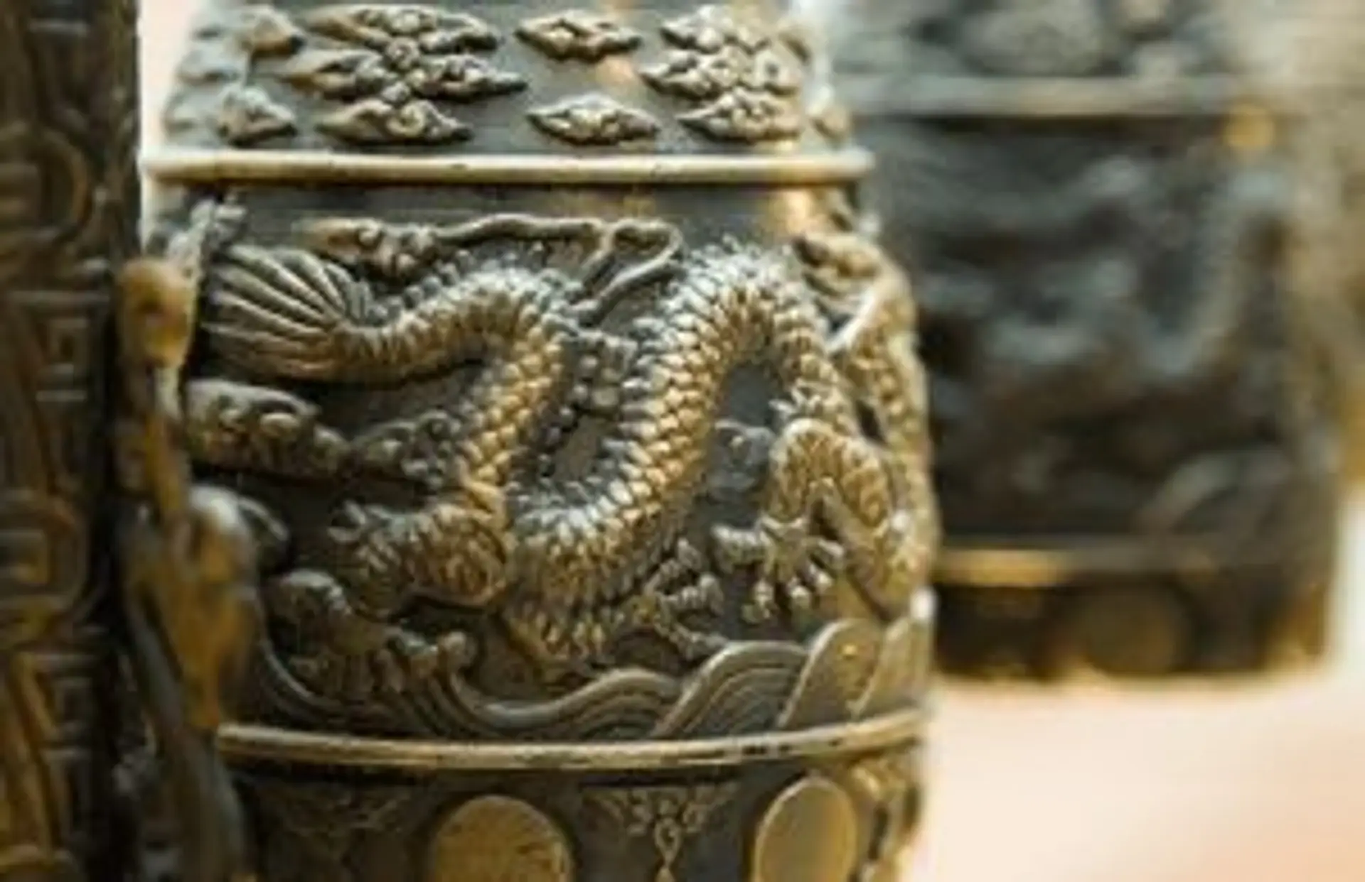 Détail d'une cloche traditionnelle en bronze gravée d'un dragon, symbole de l'histoire du Bhoutan