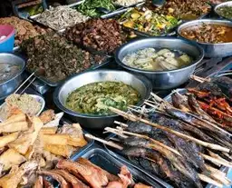 Étal de street food locale au Cambodge avec brochettes grillées et spécialités khmères