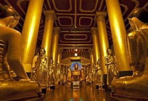 Travel in Asia - The golden interior of a Buddhist temple hall within the Shwedagon Pagoda complex in Yangon, Myanmar.