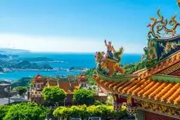 Toitures sculptées d'un temple traditionnel de Jiufen surplombant la mer à Taïwan