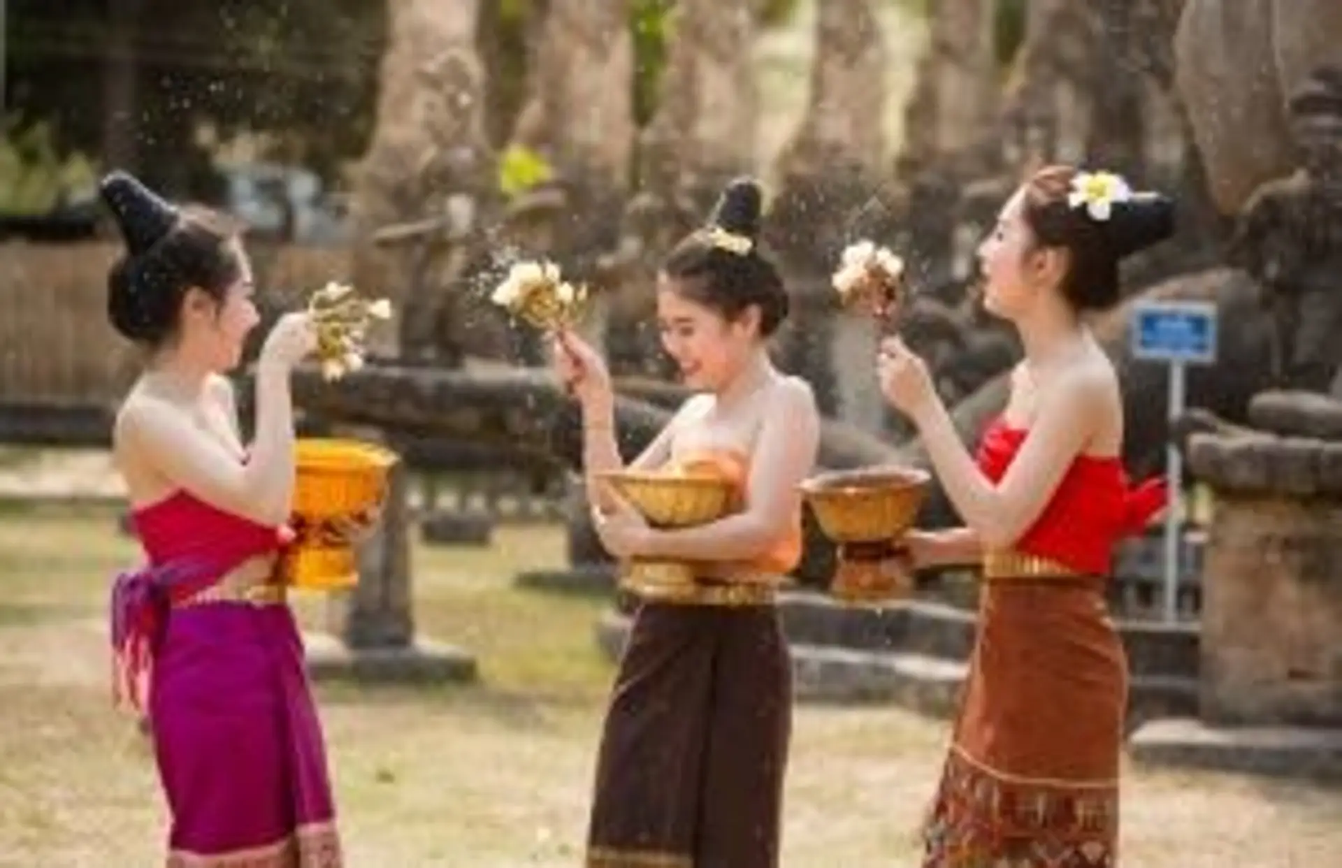 Voyage au Laos — Femmes laotiennes en tenue traditionnelle lors d'une cérémonie, illustrant la richesse culturelle du pays.