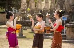 Voyage au Laos — Femmes laotiennes en tenue traditionnelle lors d'une cérémonie, illustrant la richesse culturelle du pays.