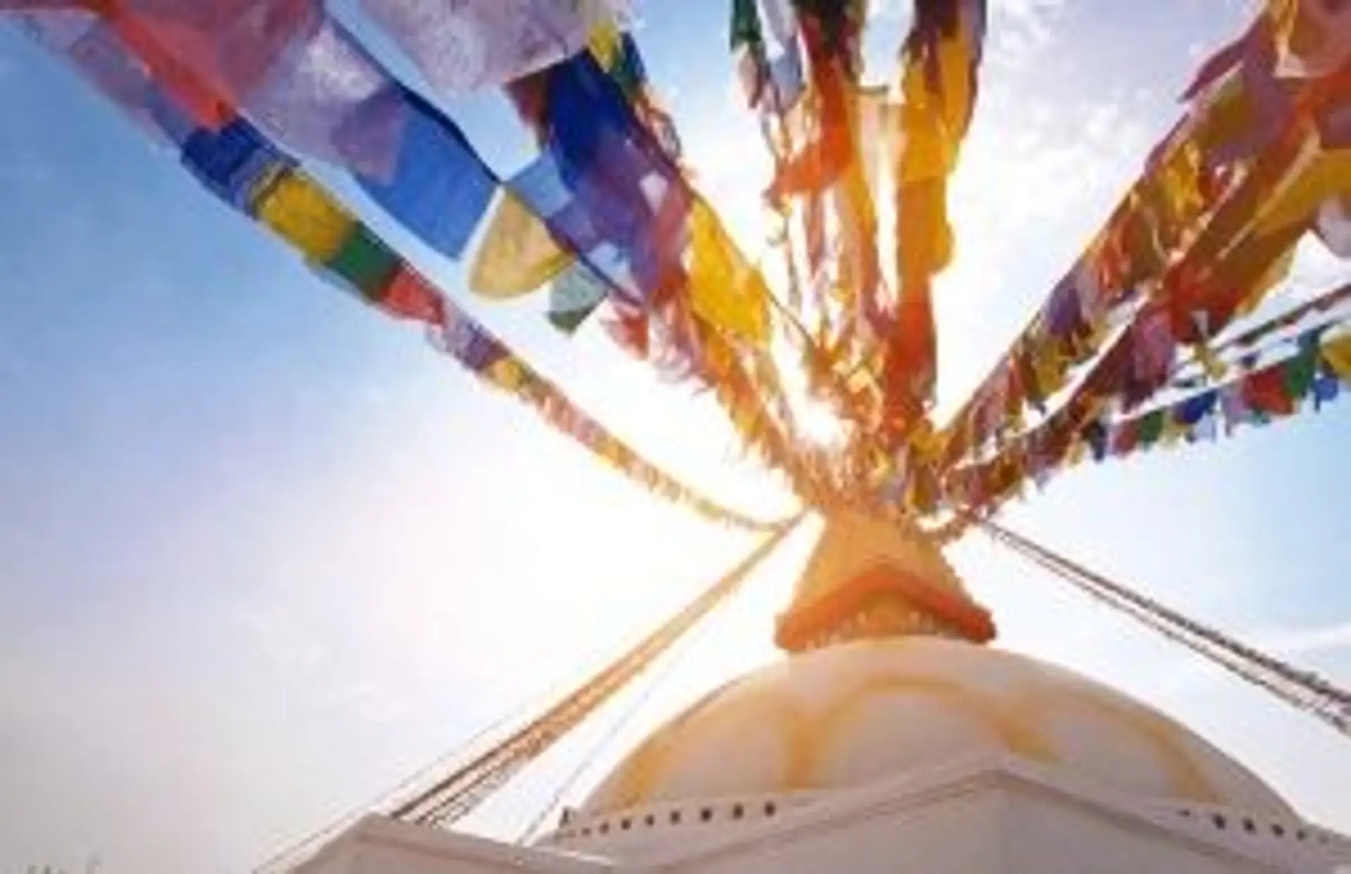 Le stupa de Boudhanath avec ses drapeaux de prières sous un ciel bleu dégagé à Katmandou au Népal