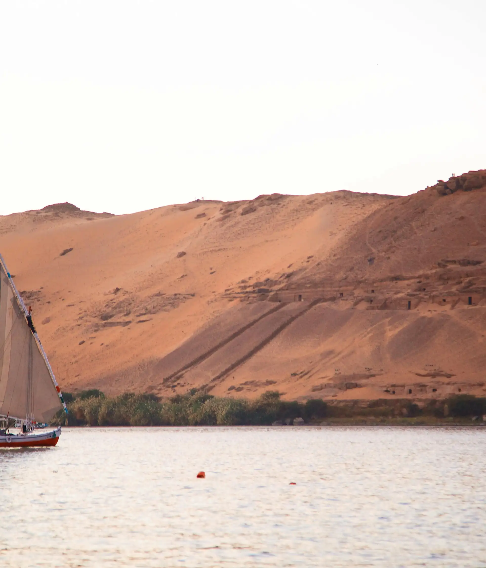 Silhouette d'une felouque naviguant sur le Nil au coucher du soleil en Égypte