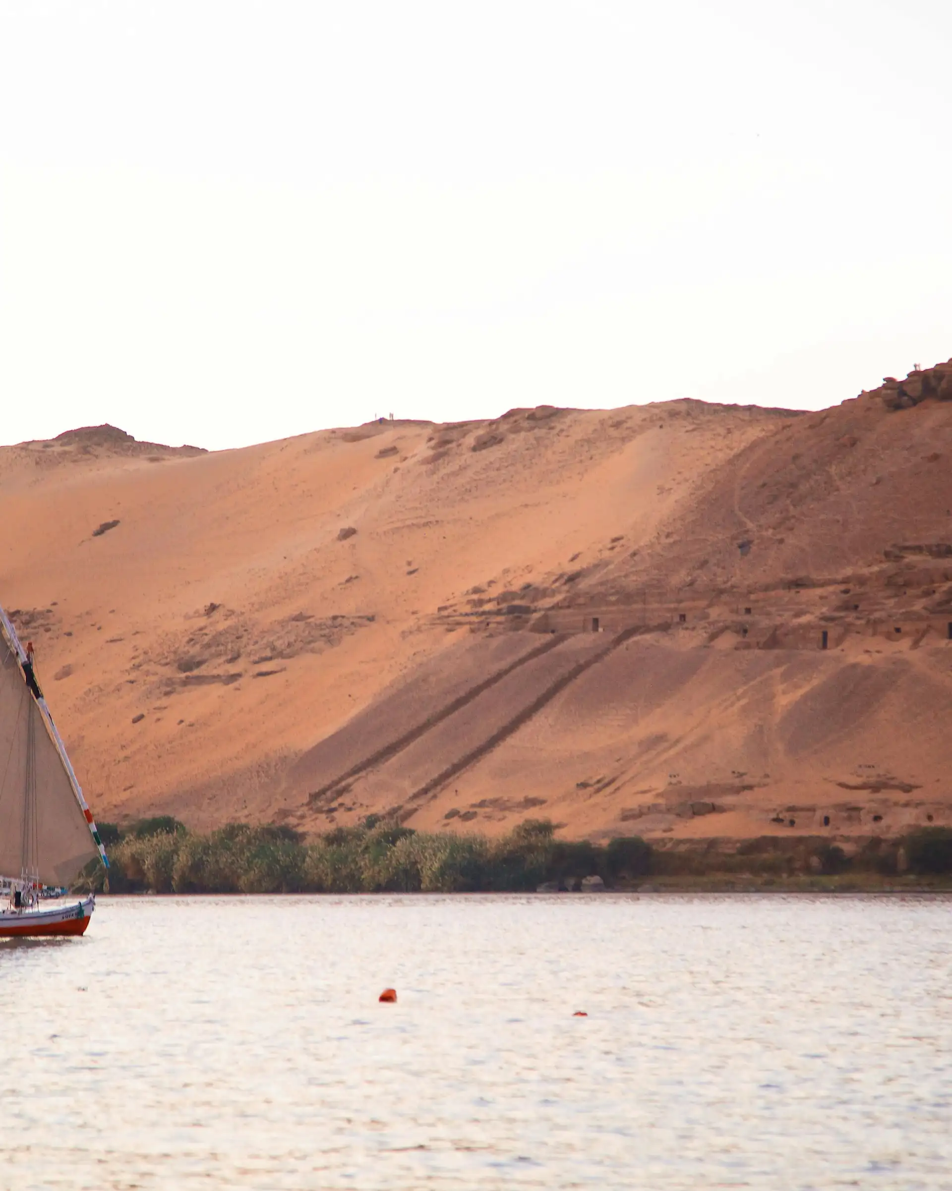 Silhouette d'une felouque naviguant sur le Nil au coucher du soleil en Égypte