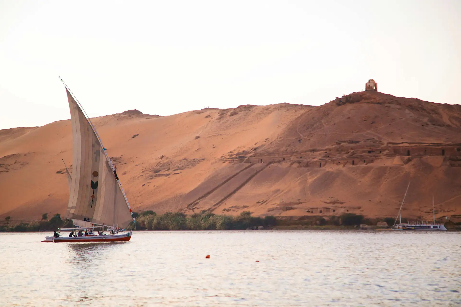 Silhouette d'une felouque naviguant sur le Nil au coucher du soleil en Égypte