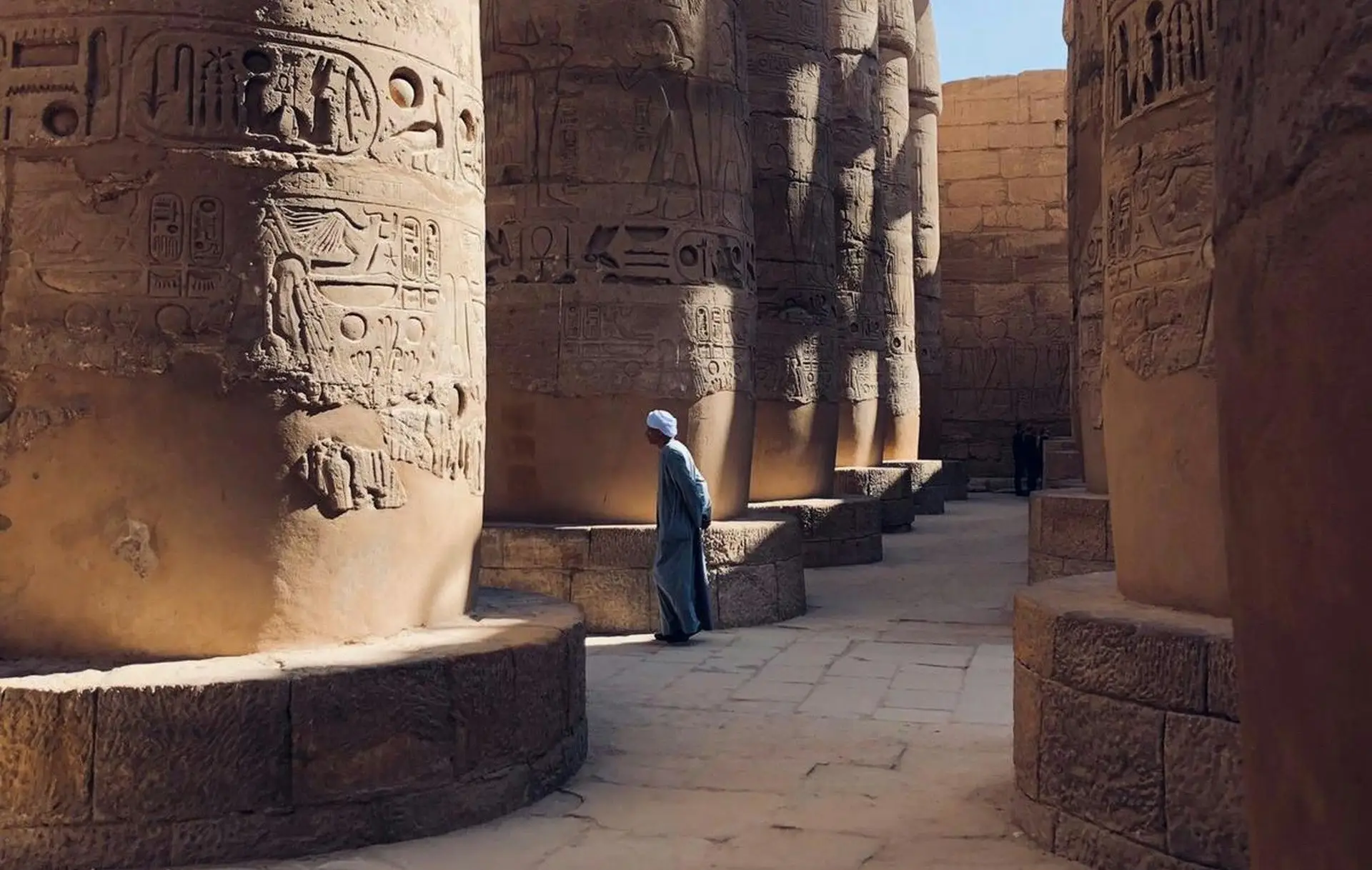 Homme marchant entre les pilliers du temple de Karnak