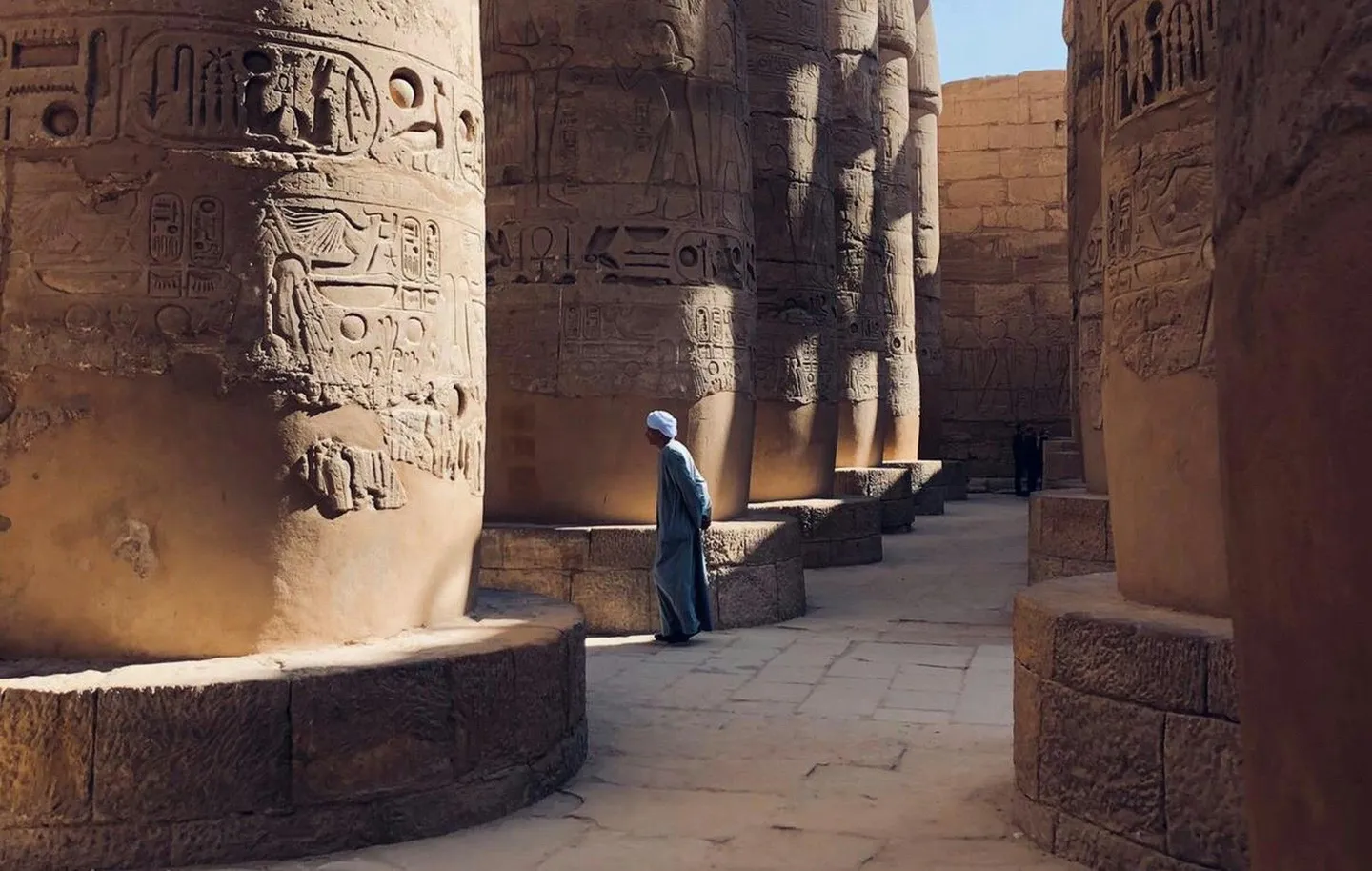Homme marchant entre les pilliers du temple de Karnak