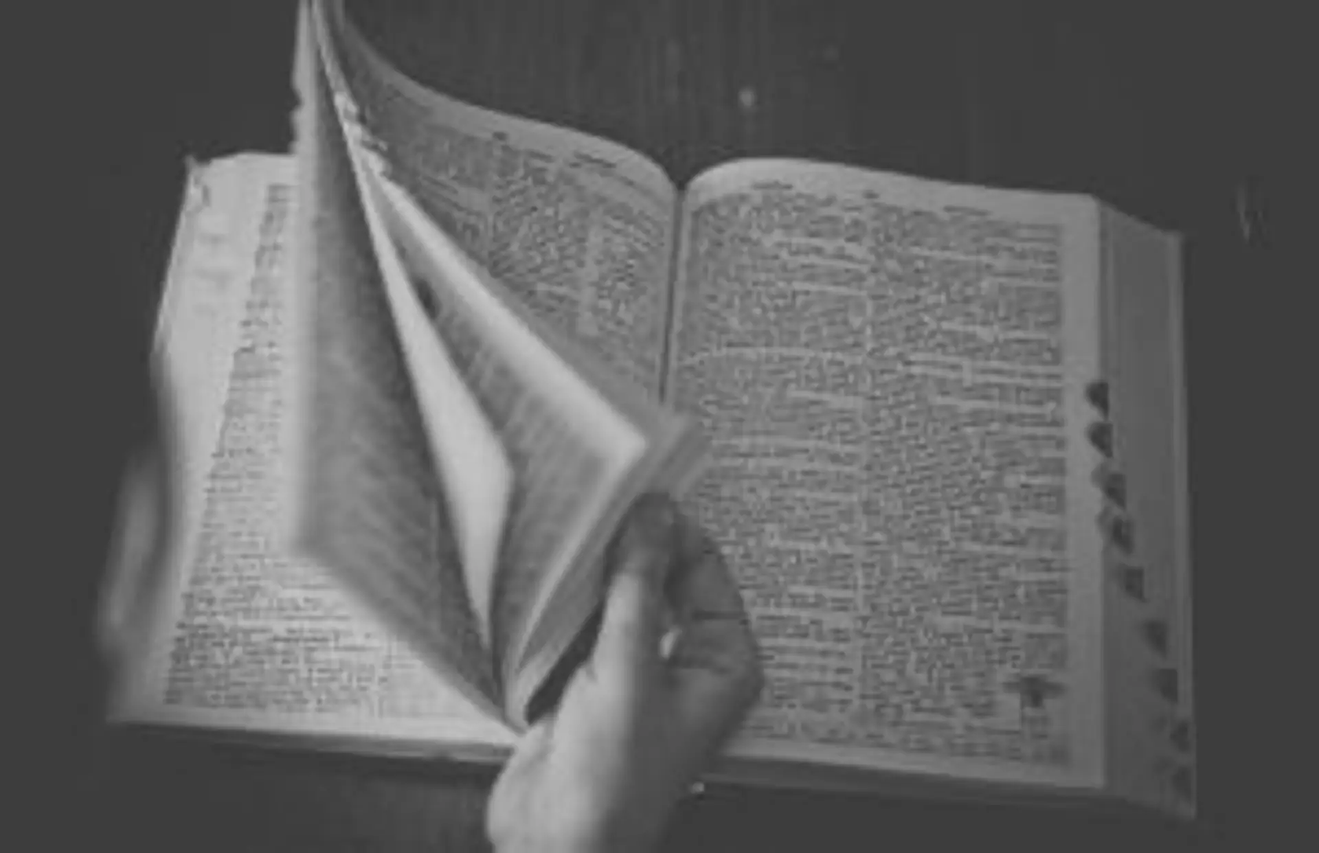 Mains feuilletant un livre ancien pour préparer son voyage et s'imprégner de la culture locale avant le départ.