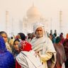 Travel in Asia - A crowd of people in traditional clothing in front of the Taj Mahal in India