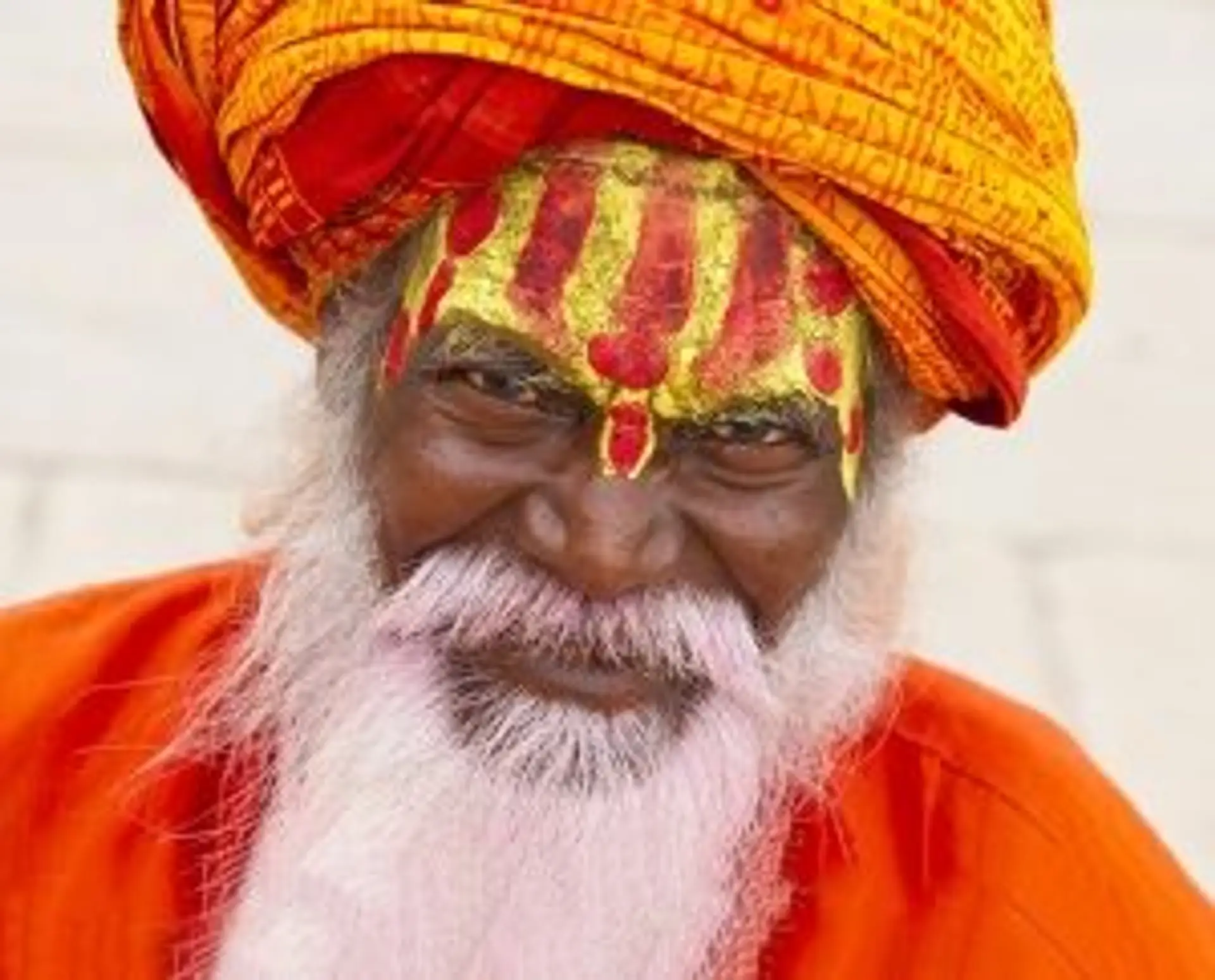 Travel in Asia - An Indian holy man with white beard wearing bright red orange clothing