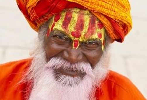 Travel in Asia - An Indian holy man with white beard wearing bright red orange clothing