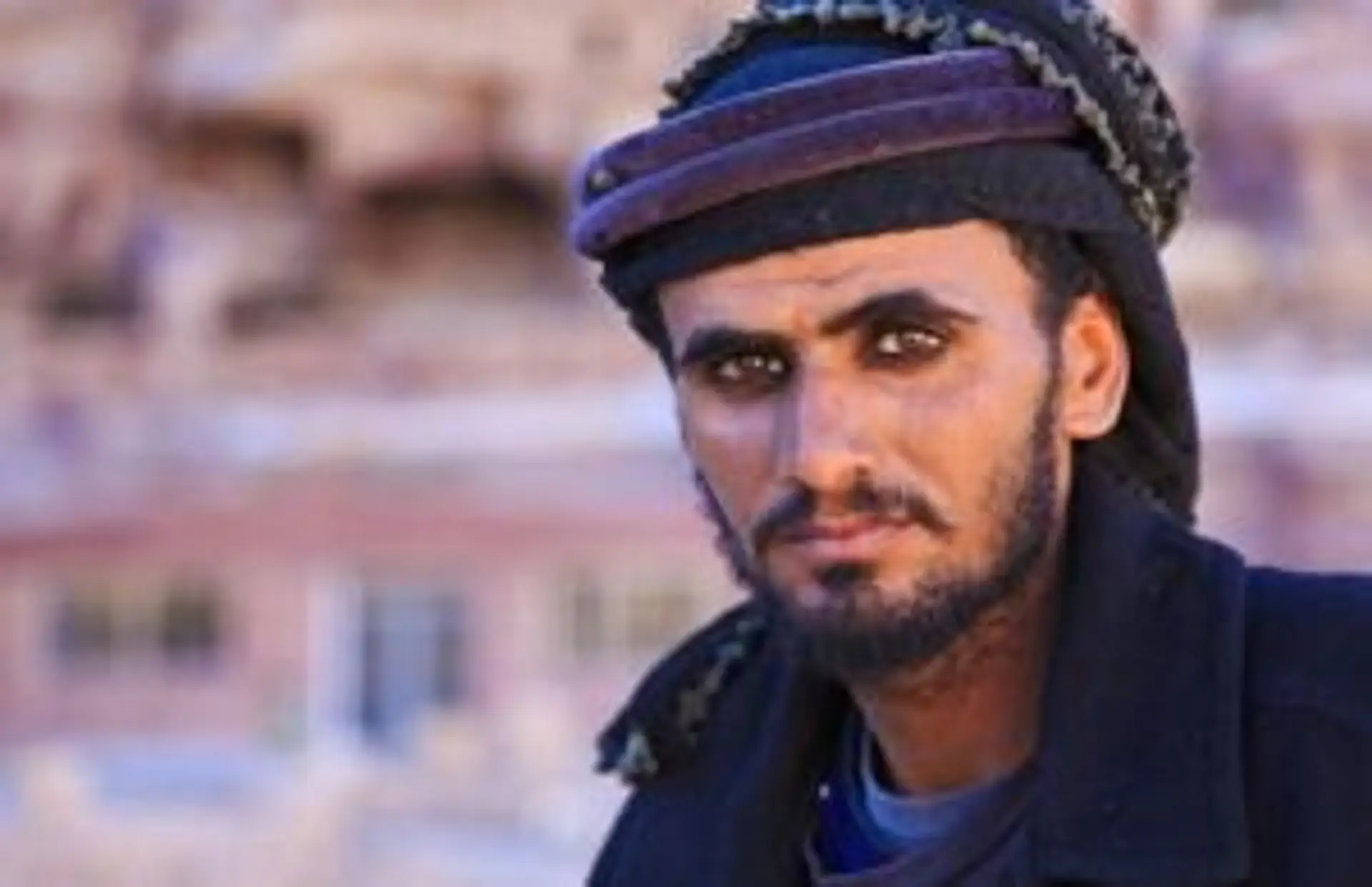 Portrait d'un homme bédouin jordanien avec un chèche traditionnel devant les roches de Pétra