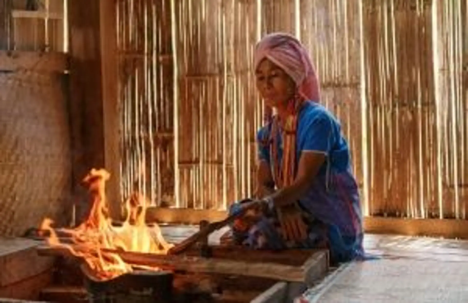 Pirogue traditionnelle thaïlandaise naviguant près de falaises calcaires dans une baie isolée