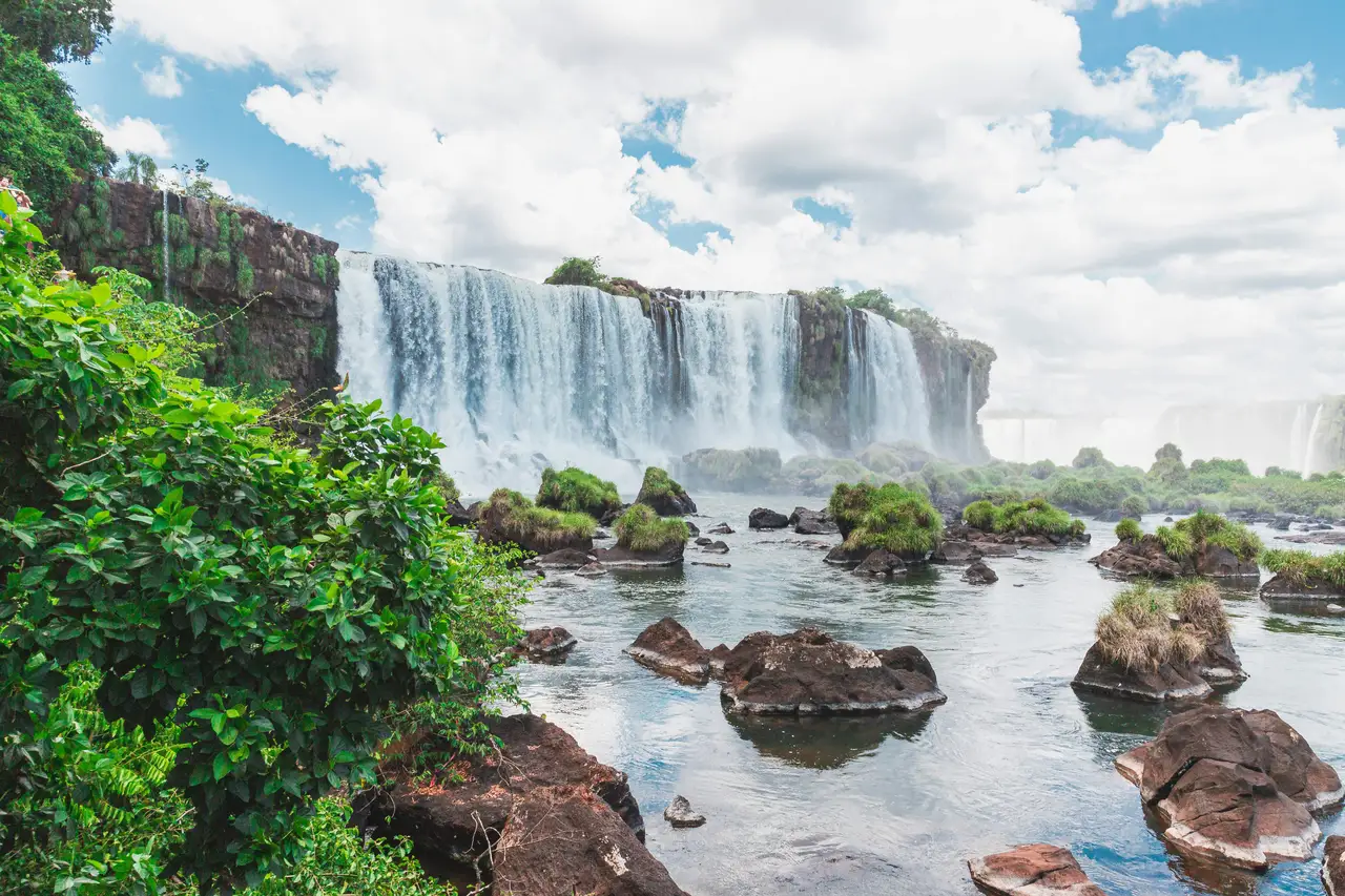 Voyage au Brésil – Vue rapprochée depuis les sentiers du versant argentin sur les puissantes cascades d'Iguazu entourées d'une végétation tropicale luxuriante.