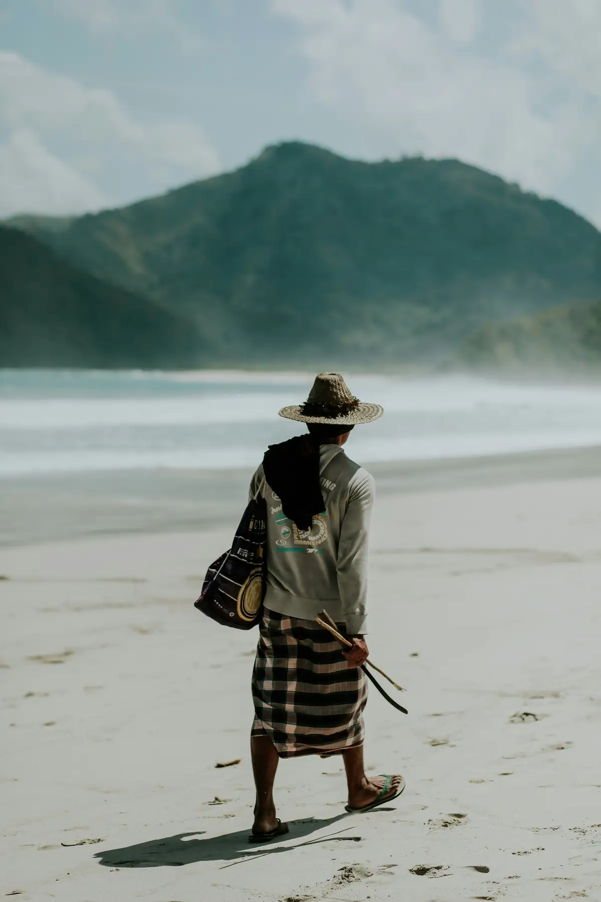 Homme Sasak marchant sur la plage de kuta Lombok