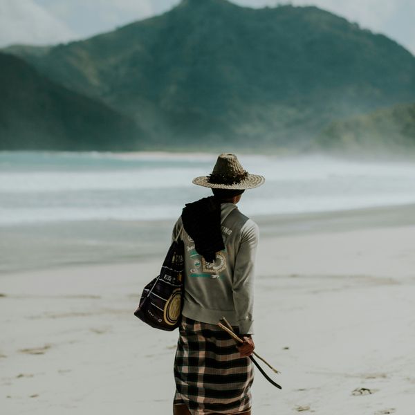 Homme Sasak marchant sur la plage de kuta Lombok