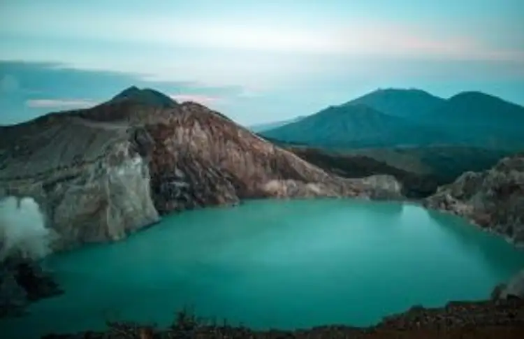 Voyage en Asie — Lac acide du cratère Kawah Ijen à Java, Indonésie : eau turquoise, parois abruptes et fumées sulfureuses dans un paysage volcanique étendu.