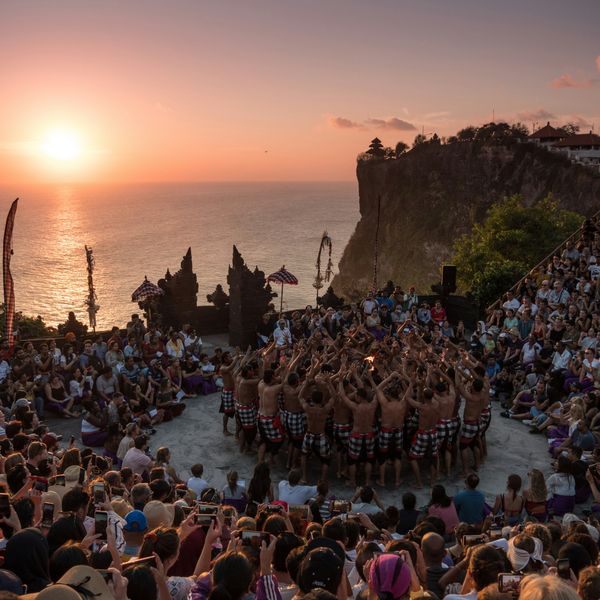 Voyage en Asie — Spectacle de danse Kecak au temple d’Uluwatu à Bali, avec les danseurs en cercle au coucher du soleil.