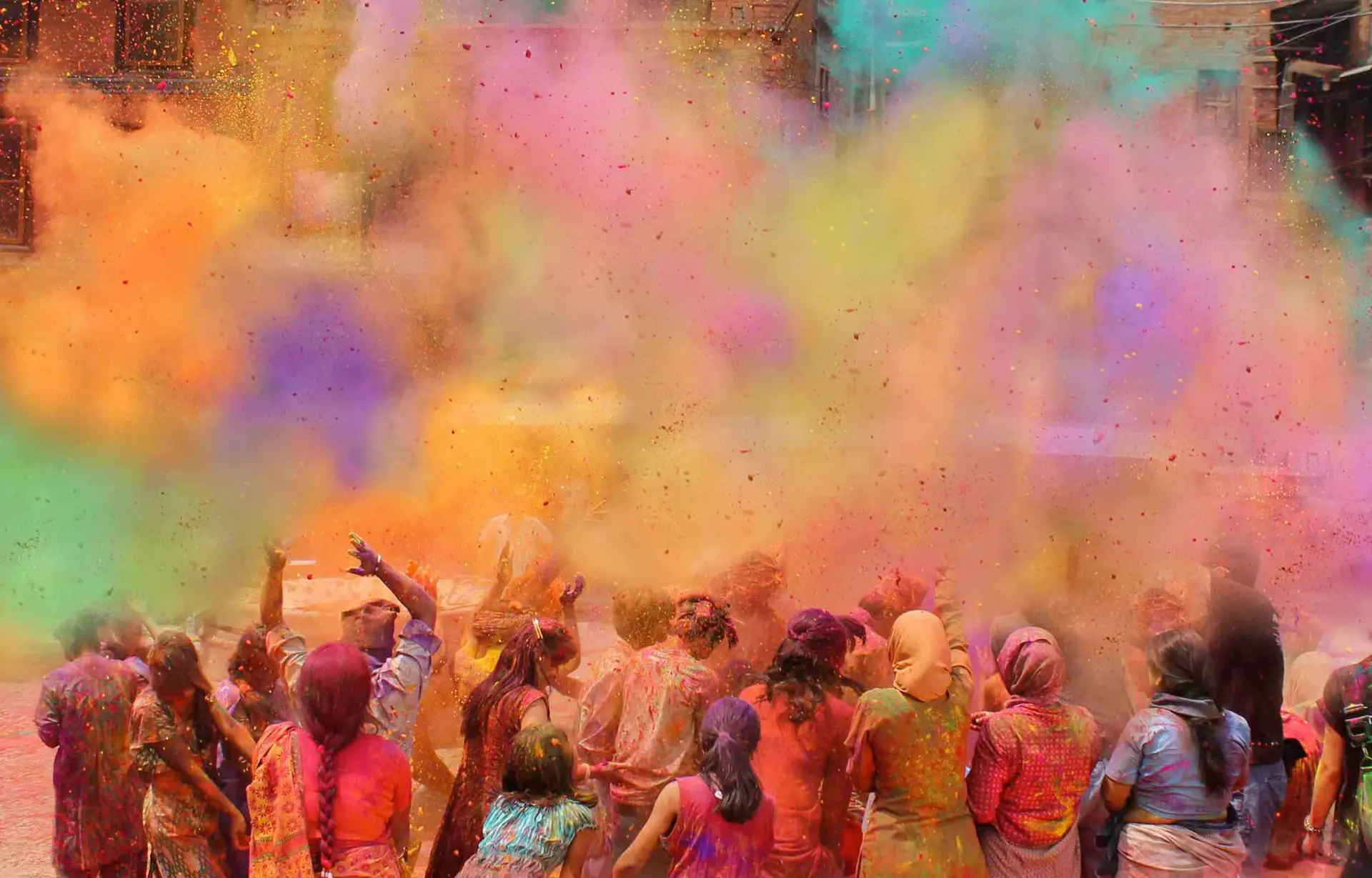 Une foule en liesse plongée dans un nuage de poudres colorées lors des célébrations vibrantes du festival Holi en Inde.