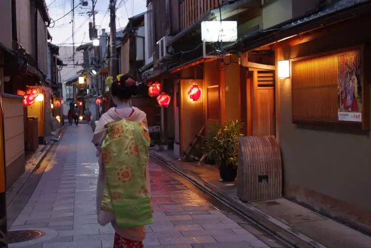Photo d'une geisha de dos dans une rue du quartier de Gion à Kyoto