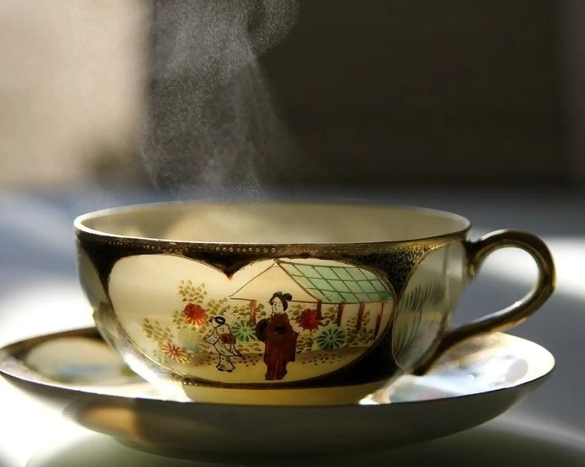 Artisanat japonais – Tasse en porcelaine traditionnelle décorée contenant du thé chaud fumant.