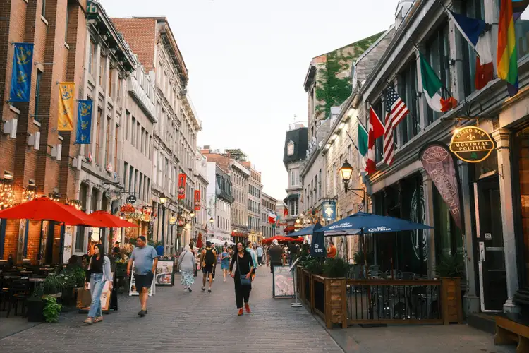 Terrasses animées et façades historiques de restaurants le long de la rue pavée Saint-Paul dans le Vieux-Montréal