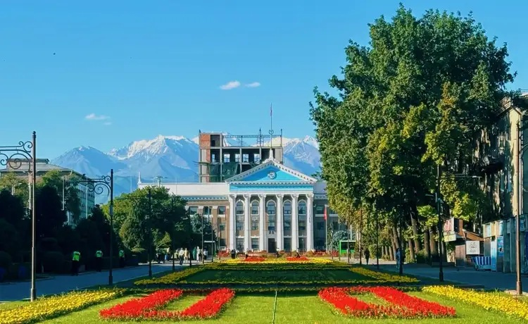 Voyage au Kirghizistan - Place principale de Bishkek fleurie devant des montagnes