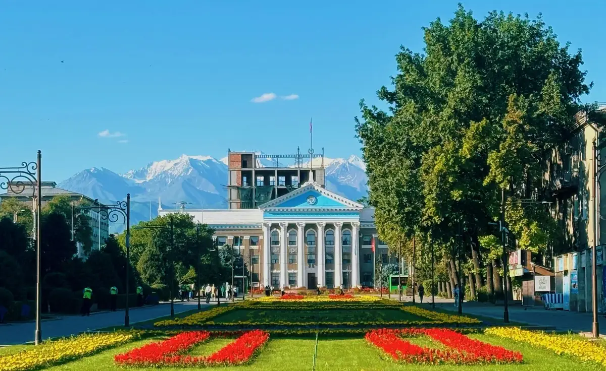 Voyage au Kirghizistan - Place principale de Bishkek fleurie devant des montagnes